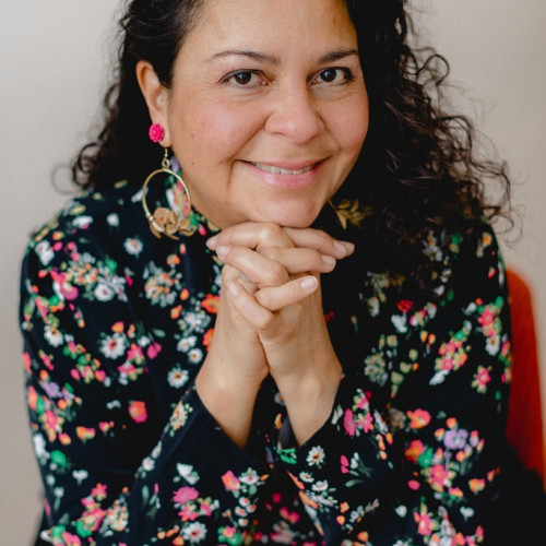 Profile picture of Lorena, wearing a black blouse with flowers.
