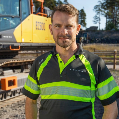 Peter Bauer steht vor einem Bagger