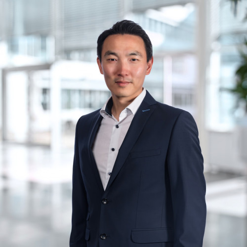 Portrait von Wei Min Wang vor Bürohintergrund